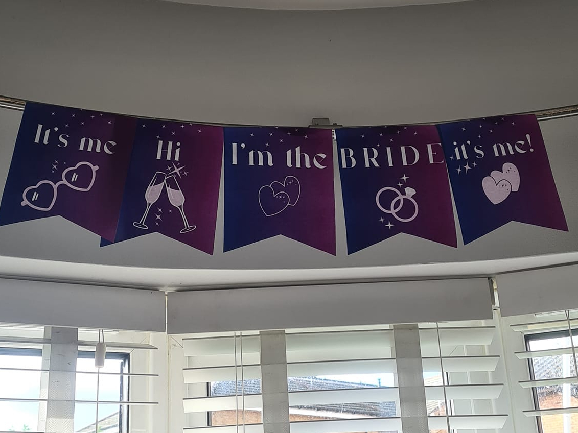 Purple bunting which says 'It's me, Hi, I'm the Bride, It's Me'